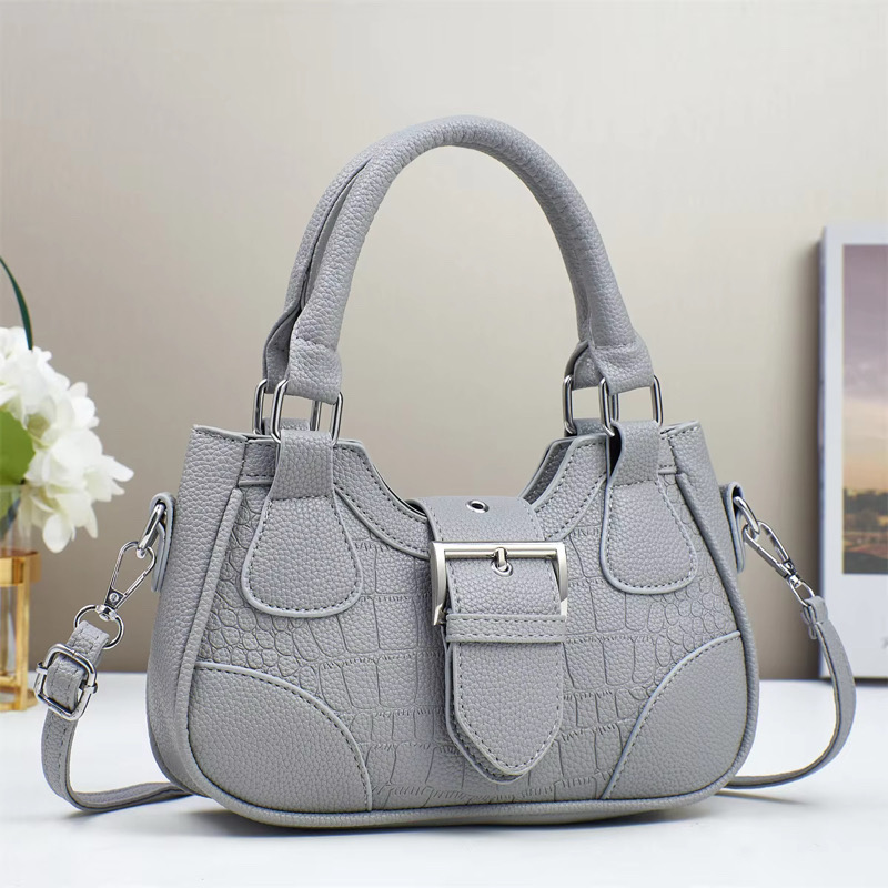 Sac à main gris Sac à main gris avec texture crocodile et poignée élégante.