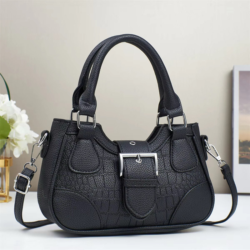 Sac à main noir. Sac à main noir en cuir avec texture imitation crocodile, anses et bandoulière.