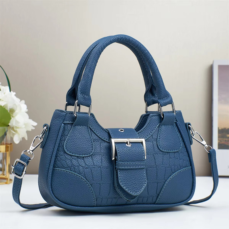 Sac à main bleu Sac à main bleu en simili cuir avec une sangle et des décorations élégantes.